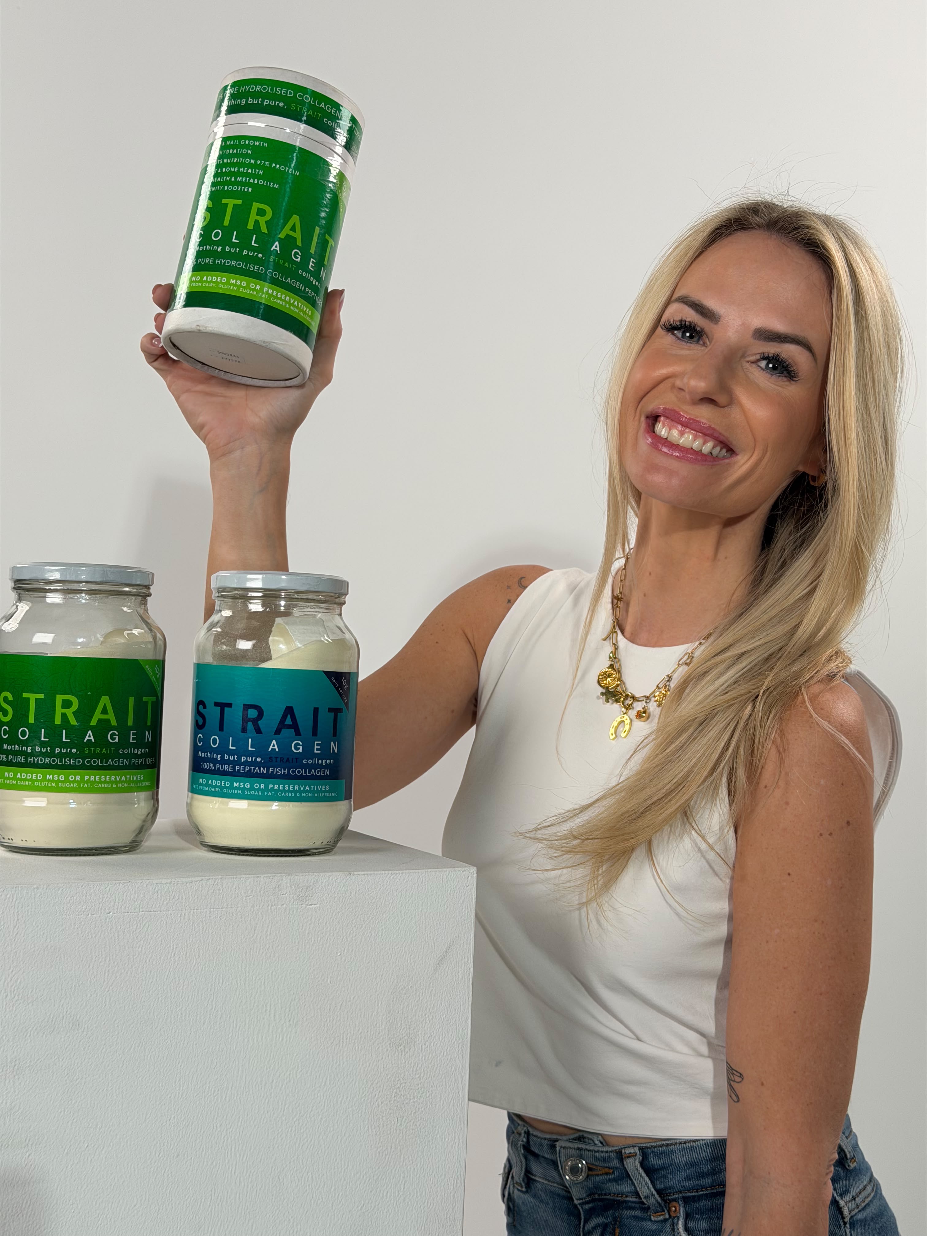 Shan holding the STRAIT Collagen tub beside the bovine and fish jars